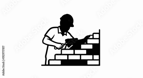 A silhouette of a construction worker in a hard hat building a brick wall