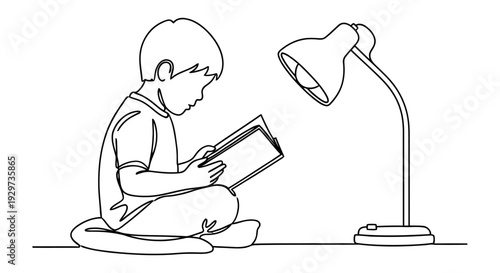 Young boy reading book under desk lamp