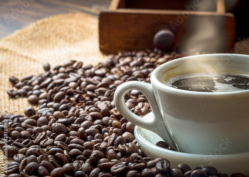 Steaming Hot Coffee Cup with Roasted Beans and Grinder