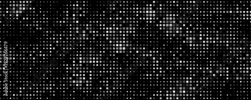 Abstract dark background of small squares or pixels in shades of black and gray colors.