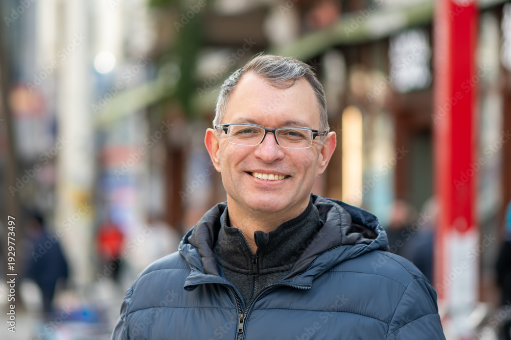 Obraz premium Portrait of adult man in urban environment with pedestrians background