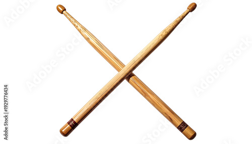 Two wooden drumsticks are crossed diagonally against a stark black background