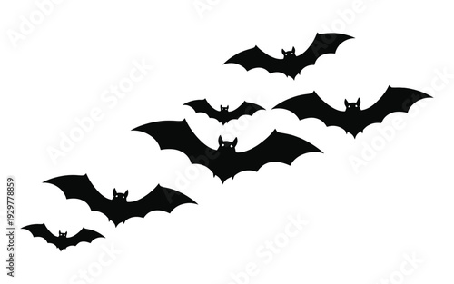A flock of bats flying together in the night sky silhouette