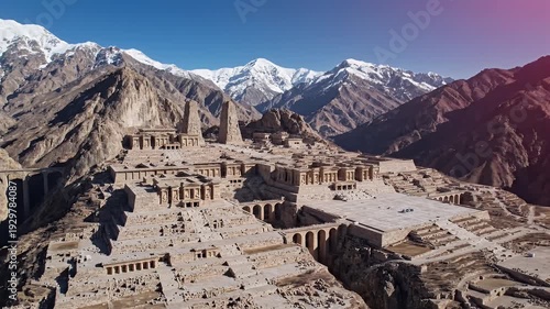 Ancient Desert Ruins Amidst Snow Capped Mountains Under Bright Sky