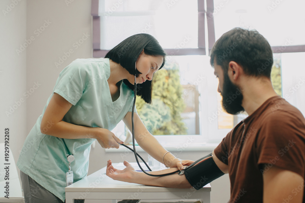 Obraz premium Nurse measuring patient's blood pressure in clinic