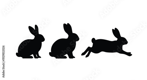 Three black rabbit silhouettes are depicted in varying poses against a stark white background showcasing simple forms silhouette