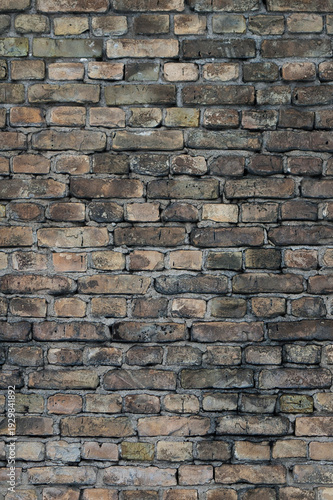 Old brick wall of a building, the photo shows the texture of yellow-brown bricks of the building's facade