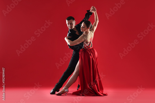 Fotografija Couple of professional dancers on red background