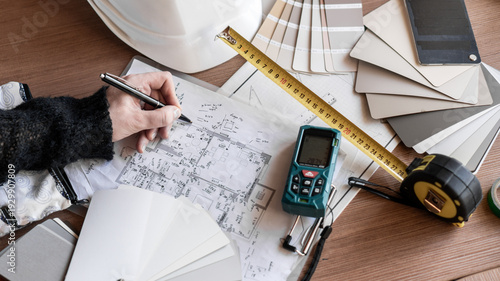 Fotografi female interior designer writes down apartment measurements and makes drawings