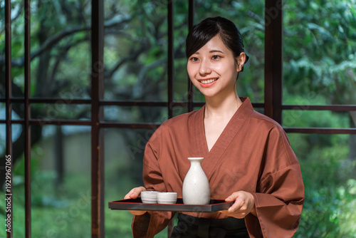 Bild auf Leinwand A waitress bringing sake to a guest room, a female inn staff member