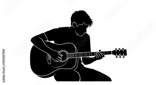 Man sitting on the floor playing acoustic guitar.