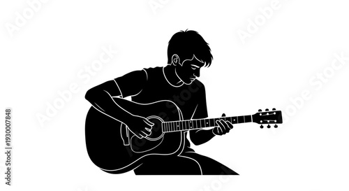 Man sitting on the floor playing an acoustic guitar.