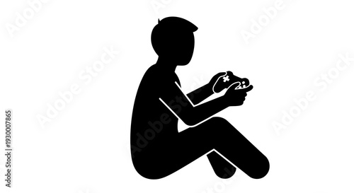 Silhouette of a boy sitting and playing video games on a console.