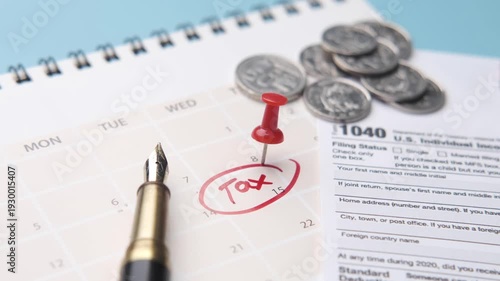 A close-up view of a calendar with a 'tax' reminder, a tax form, coins, and a pen, symbolizing the tax season and financial planning
