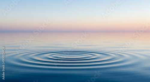 Concentric ripples on calm water surface at sunset