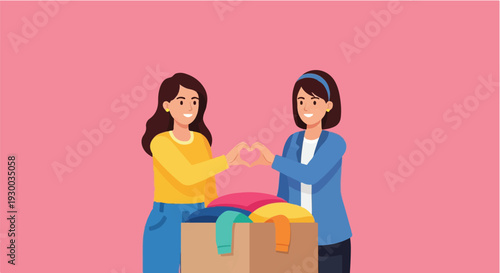 Two smiling women make heart shapes with their hands above a box of clothes, symbolizing charity and community support
