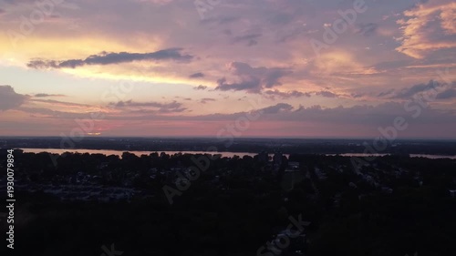 Flying very slowly from right to left, with a drone, way above the city at sundown