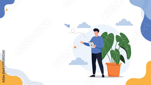 Man using a digital tablet for work or communication while standing near a large green houseplant in an office.