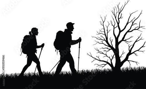 Black silhouette of a man and woman hiking with backpacks and trekking poles in a grassy field near a tree