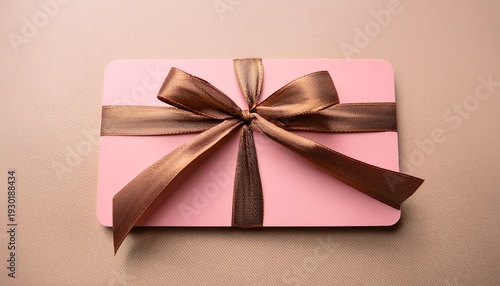 Blank Pink Gift Card With A Shiny Bronze Ribbon And Bow On A Light Beige Background For Special Occasions