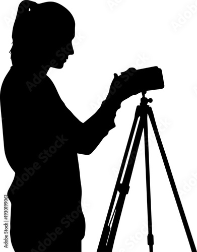 Woman photographer silhouette operating camera on tripod