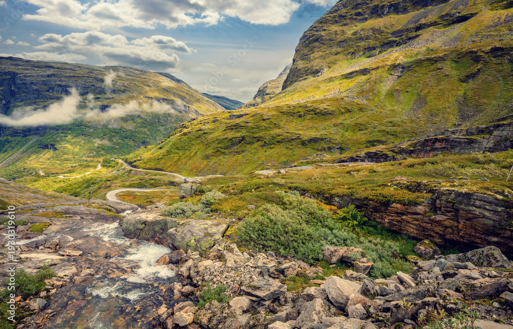 Obraz premium Autumn mountain landscape in Norway. Winding road in the mountains. Road 63 to Geiranger. View from Upper Blaafjeld Bridge