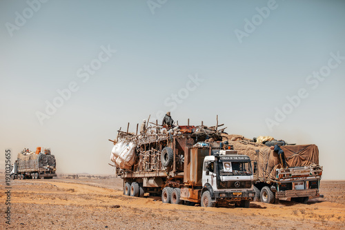 Fotografie Trucks laden with cattle navigate the remote desert routes between Chad and Libya, a lifeline in the vast, unforgiving landscape