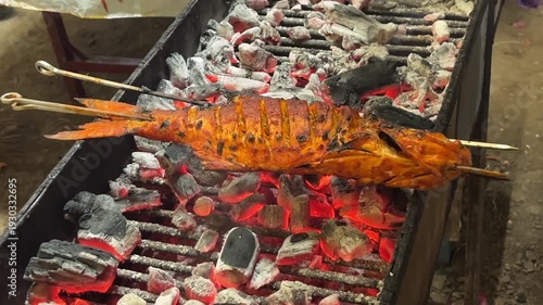 Delicious grilled fish on skewers over open flame barbecue