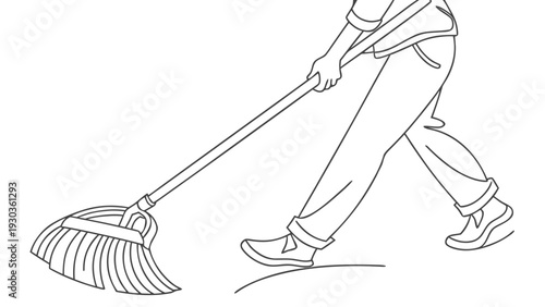 Person raking leaves with a large rake outdoors