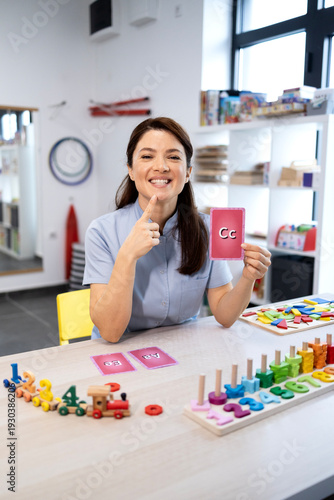 Bild auf Leinwand Female speech therapist working with flashcards and educational toys, teaching a