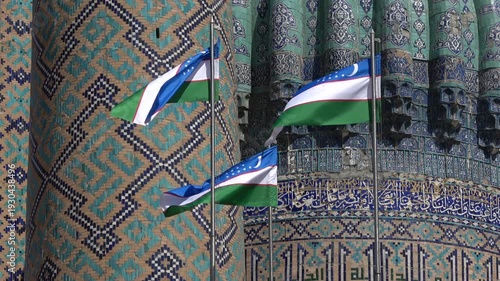 Flags of Uzbekistan on the background of an ancient madrasah. Registan Square, Samarkand