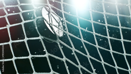 Photography An ice hockey puck hitting the back of the net as it scores a goal