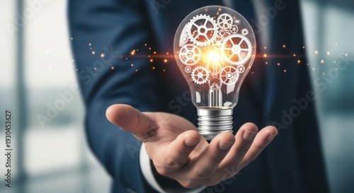 Closeup Businessman Hand holding virtual light bulb with gears, representing industrial innovation, engineering ideas, creative manufacturing, and technical problem solving solutions.