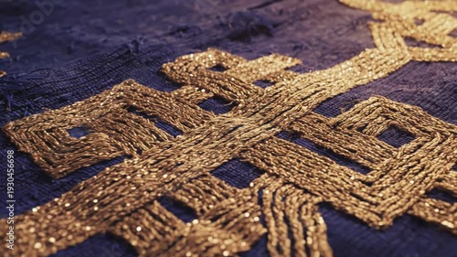 Close-up of intricate gold embroidery on dark fabric background