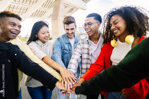 Fotografie Group of cheerful gen z students standing together, holding hands as a sign of support and togetherness