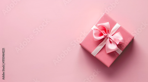 A minimalist flat lay of a pink gift box on a soft pink background.