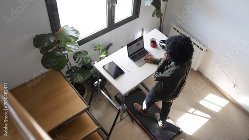Obraz na płótnie Person multitasking, staying active and focused while working remotely on a lapt