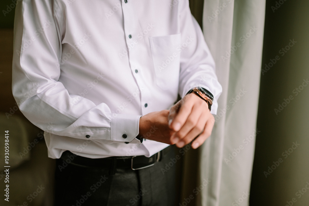Obraz premium Man in elegant white shirt preparing for a special occasion