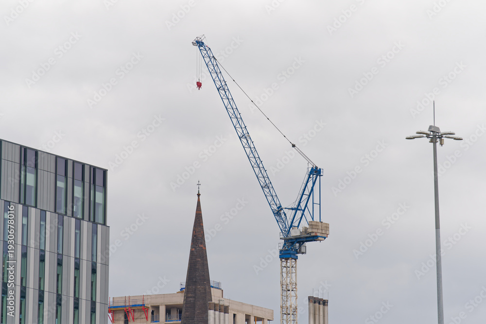 Fototapeta premium Tower cranes high in sky at construction site
