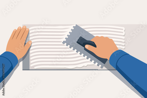 Worker applying adhesive mortar with a trowel tool for tiling installation