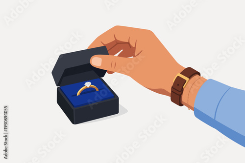 Man's hand holding open engagement ring box with diamond for a marriage proposal