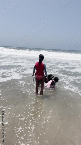 Father selfie POV with kids and dog playing in beach waves