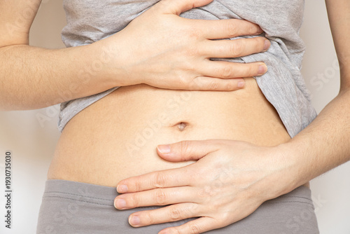 Photography A woman holding her stomach with her hands for topics on abdominal pain, cramps,
