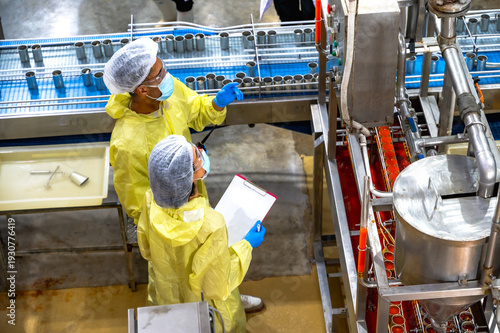 Male and female food factory inspector working and inspecting frozen food in manufacturing process
