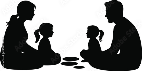 Silhouette of a family playing a board game together with their two young daughters in a relaxed indoor setting
