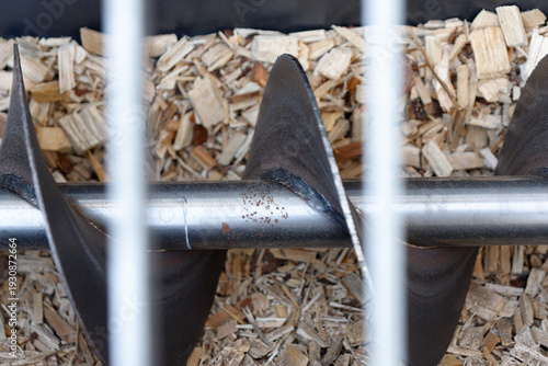 Biomass boiler auger feeding wood chips for renewable energy
