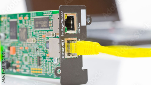 Close-up of ethernet cable connecting to circuit board with UPS data settings