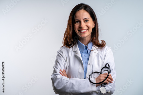 Female doctor smiling with arms crossed on white background