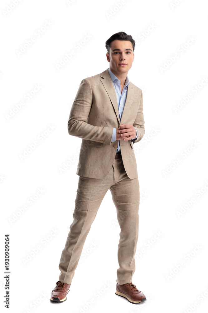 Fototapeta premium Confident man rubbing hands together in beige linen suit