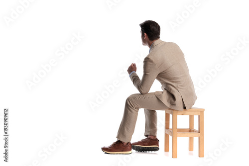 Back view of pensive man sitting on wooden chair